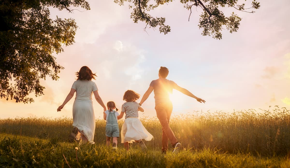 Family with two children happily walking through a field
